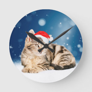 Horloge Ronde Chat mignon portant chapeau de Noël rouge neige