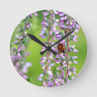 Horloge Ronde Coccinelle sur fleur violette -