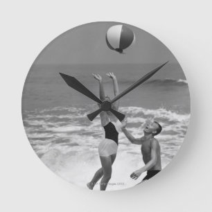 Horloge Ronde Couples jouant avec un Beachball