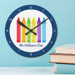 Horloge Ronde Cute maternelle Enseignant Crayon Custom Classe<br><div class="desc">Un beau cadeau de la Semaine d'appréciation de l'enseignant ou de la fin de l'année pour un cours de jardin d'enfants à donner à leur enseignant de l'école primaire. Horloge faite sur mesure avec leur nom customisé en bleu. Personnalisez avec votre nom ou texte sous l'arc-en-ciel mignon des crayons. Un...</div>