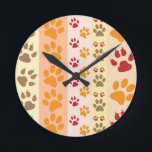Horloge Ronde Empreintes de pattes Amoureux de les chiens mignon<br><div class="desc">Conception avec un motif mignon d'empreintes de pattes de chien dans les couleurs orange et jaune et chaud. Ce design ressemble à un chien qui a parcouru le produit ! Pour les amoureux de les chiens partout.</div>