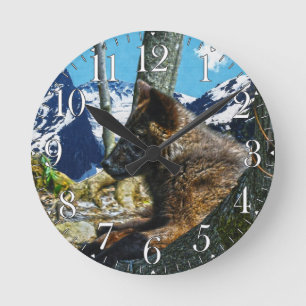 Horloge Ronde Loup noir de montagne reposant par les arbres Art