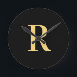 Horloge Ronde Monogramme moderne Noir Or<br><div class="desc">Il s'agit d'un monogramme simple, moderne et personnalisé. Ce design élégant est en noir et or tendance avec typographie stylisée. Il est parfait pour un cadeau personnalisé ou idéal comme un nouvel accessoire design de décoration maison pour vous-même. Ajoutez simplement votre lettre initiale en la tapant dans la zone de...</div>