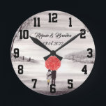 Horloge Ronde Parapluie rouge Amour couple rustique romantique M<br><div class="desc">Parapluie rouge peinture à l'aquarelle. Couple d'amoureux avec parapluie rouge. Belle œuvre d'art peinte à la main par moi-même. Parfait pour les jeunes mariés,  couple. Cadeau d'anniversaire de mariage. Cadeau de la Saint-Valentin. Vous pouvez le personnaliser avec vos noms et date.</div>