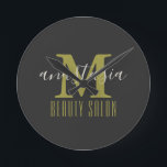 Horloge Ronde Salon de beauté noir par Anastasia Monogramme<br><div class="desc">Le Black Beauty Salon by Anastasia Monogram Round Clock. Gold monogram letter with name of business and owner on black background. Customize it with your own information. @Miri Creations - Created For You Only with You In Mind ! Copyright Miri Creations,  tous rights reserved.</div>