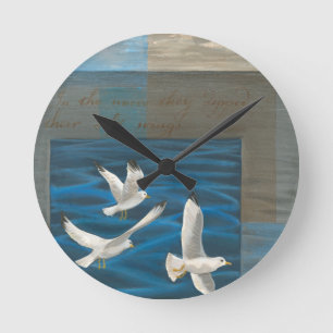 Horloge Ronde Trois mouettes blanches volant au-dessus de l'eau