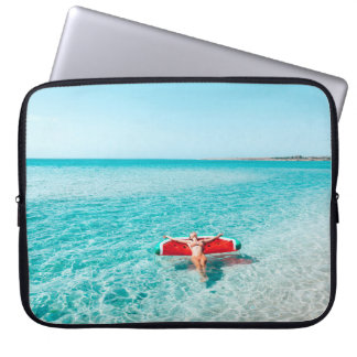 Housse Pour Ordinateur Portable Femme sur lilo dans l'eau de mer. Fille se relaxer