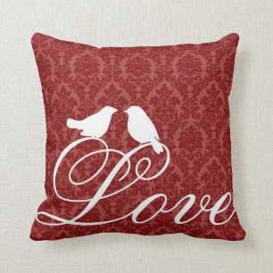 Inséparables sur le coussin rouge de damassé