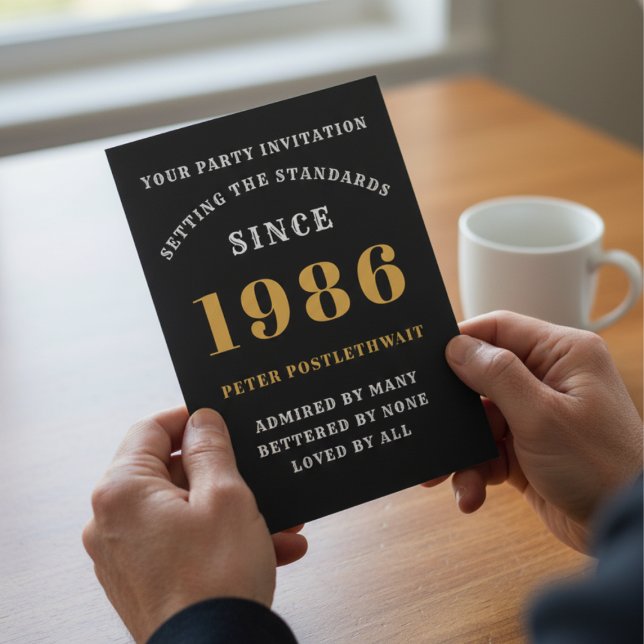 Invitation 40e anniversaire 1986 Black Gold Personnalisé Pour (1986 40th birthday invitation held in hands over a table.)