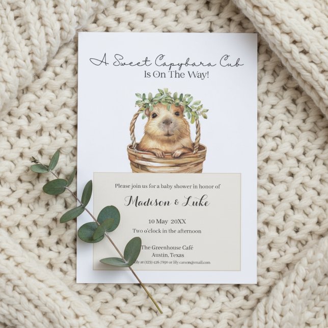 Invitation Fête de bébé capybara • Décor eucalyptus (Baby shower invitation with capybara design on cream knitted blanket and eucalyptus sprig)