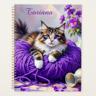 Joli chat avec des fleurs violettes et de la laine