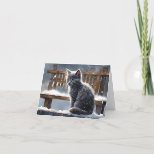 Joli chat gris sur un banc en hiver neige Carte de