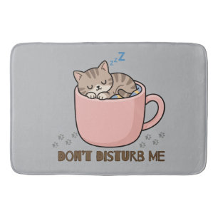 Joli petit chat endormi dans un tapis de bain en f