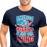 L'Amérique numéro un remporte le t-shirt patriotiq<br><div class="desc">Montrez votre fierté américaine avec ce t-shirt audacieux et patriotique ! Avec l'expression "America #1, Winning is Just Our Thing" aux côtés du drapeau et des étoiles américains, ce design est parfait pour célébrer le Jour de l'Indépendance, le Jour du Souvenir, le Jour des Vétérans, ou toute occasion où vous...</div>