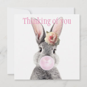 Lapin gris soufflant du bubble gum avec une fleur