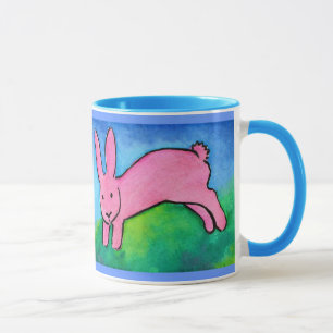 Lapin rose avec la tasse bleue de poignée