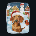 Linge De Bébé Dachshund Winter Wonderland Christmas Joy<br><div class="desc">Ce design festif reflète l'esprit joyeux de la période des fêtes, avec un adorable petit portant un chapeau de Père Noël. Le chien est niché dans un pays des merveilles hivernales, avec un bonhomme de neige, un sapin de Noël décoré et des cadeaux joliment emballés. Les flocons de neige tombent...</div>