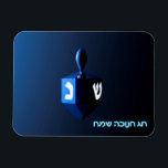 Magnet Flexible Dreidel bleu brillant<br><div class="desc">Un rêve moderniste bleu métallique contre un arrière - plan sombre et nocturne. Deux des lettres hébraïques trouvées sur un dreidel,  une nonne et un shin,  brillent brillamment. Le texte hébreu "Chag Chanukkah Sameach" (Hanoukka heureuse) apparaît également en bleu et blanc éclatant.</div>