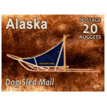 Magnet Photo Sculpture Timbre de poste de courrier de traîneau de chien d<br><div class="desc">Le timbre-poste 20 Nugget émis par un Alaska indépendant imaginaire commémorant la reprise du traîneau à chiens. Un traîneau à chiens moderne est représenté superposé à une image arrière - plan de fourrure de caribou (rennes). La motoneige a un sac bleu de traîneau arborant le drapeau de l'Alaska et le...</div>