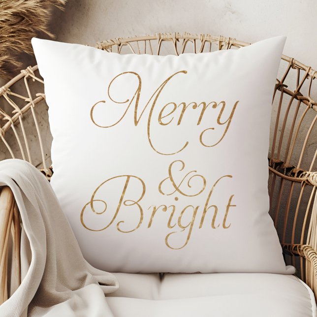 Merry & Bright - Coussin de Noël en or et blanc (Merry & Bright - Gold and White Christmas Pillow on a boho rattan armchair.)