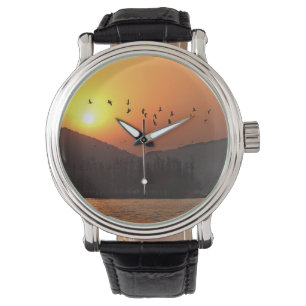 Montre Birds Flying dans le lac Est de Sunset Sky