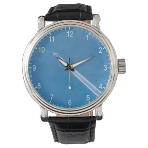 Montre L'avion vole dans le ciel bleu