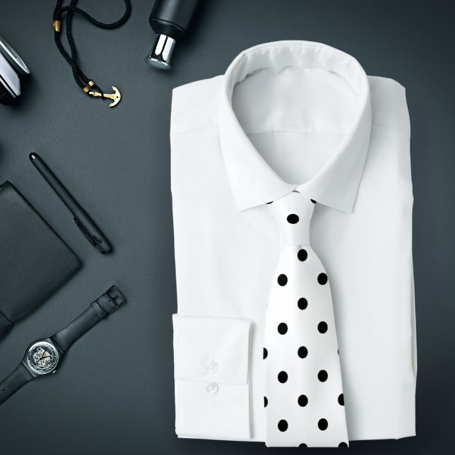 Motif à pois noirs classiques sur une cravate blan (A white tie with black polka dots is featured on an assemblage of men's accessories.)