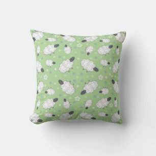 Moutons et fleurs sur un oreiller vert