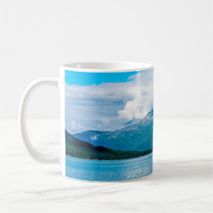 Mug A peninsula of land covered in pine forest juts ou