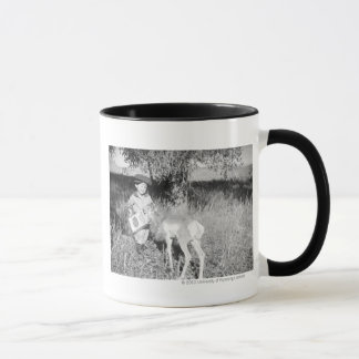 Mug Antilope de alimentation de garçon à la main