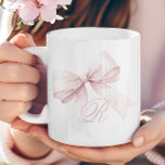 Mug Bow rose<br><div class="desc">Ajoutez une touche d'élégance et de féminité à votre routine matinale avec cette belle tasse avec un délicat arc rose et un monogramme initial de script personnalisé. Le design doux et girly en fait un ajout élégant à votre cuisine, apportant un accent mignon et tendance à votre café ou thé....</div>