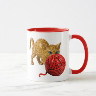 Mug chat 3D, yeux bleus, dos rond et pelote rouge.
