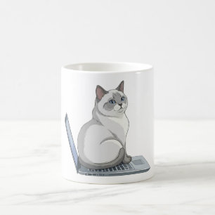 Mug Chat assis sur le clavier d'un ordinateur portable