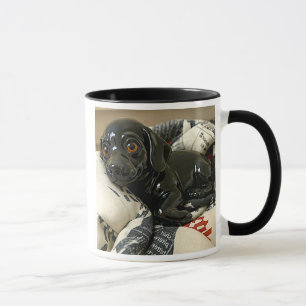 Mug chiot noir 3D sur coussins, design original.