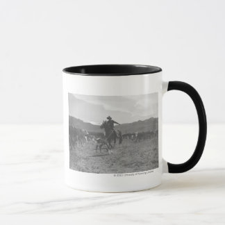 Mug Cowboy roping un veau pour le marquage à chaud de