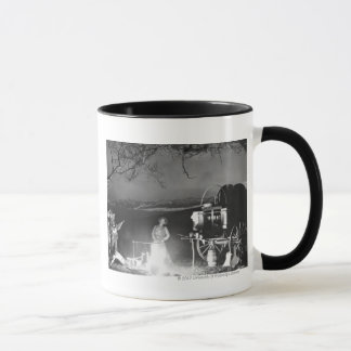 Mug Cowboys jouant et chantant autour d'un feu de camp