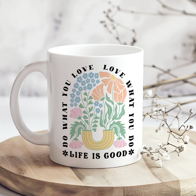 Mug "Faites ce que vous aimez" Arc floral rétro ("Do What You Love" Retro Floral Arch Coffee Mug on a boho wooden kitchen table next to dry flowers.)