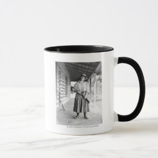 Mug Femme tenant un fusil sur un porche