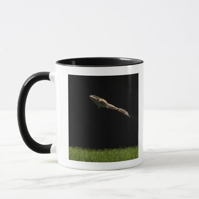 Mug grenouille sautant outre de l'herbe verte fraîche (Gauche)