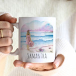 Mug La vie est meilleure à la plage Personnalisé<br><div class="desc">Ces belles tasses à café personnalisées présentent une aquarelle sereine d'une femme debout au bord du rivage, tenant un casquette de plage, avec des tons doux de rose et bleu évoquant une scène océanique sereine. Les mots "La vie est meilleure à la plage" sont élégamment inscrits dans la typographie du...</div>