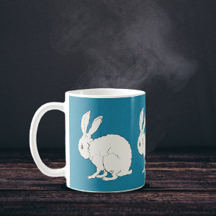 Mug lapins de lapin assis blanc élégant sur le bleu