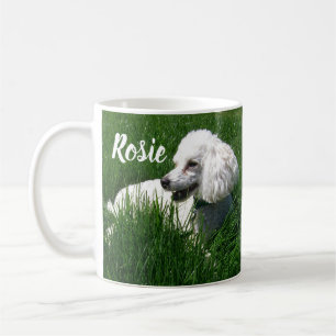 Mug Un caniche blanc reposant dans l'herbe verte luxur