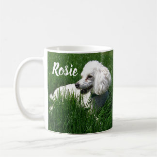 Mug Un caniche blanc reposant dans l'herbe verte luxur