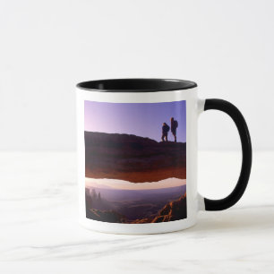 Mug Un couple observe le lever du soleil depuis le som