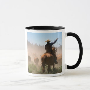Mug Un cow-boy travaillant le troupeau dans un élevage