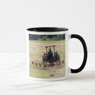 Mug Un jeune garçon conduisant une moisson de tracteur