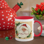 Mug Vintage Santa in Frame<br><div class="desc">White and red 11 oz. combo mug with a vintage image, on both sides, of jolly old St. Nick on gradated green snowfall in an ecru frame adorned with holly and the sentiment “A Merry Christmas” in red script. See matching candy jar, espresso cup, flask, pitcher, paper plate, shot glass,...</div>