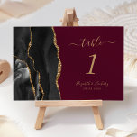 Numéro De Table Black Gold Agate Mariage Bourgogne<br><div class="desc">Le bord gauche de cette élégante carte de numéro de table mariage moderne comporte une bordure en aquarelle noire,  recouverte d'une parties scintillant en faux or. Le texte personnalisable combine écriture manuscrite de couleur or,  et polices italique et cuivre sur un arrière - plan bordeaux.</div>