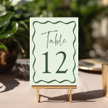 Numéro De Table Cadre de mariage ondulé vert moderne<br><div class="desc">Ajoutez une touche élégante à votre célébration de mariage avec ces cartes de table de mariage Modern Wavy Frame ! Le design rétro affiche "Table" dans un script manuscrit vert avec le numéro de table indiqué ci-dessous. Une bordure verte ondulée entoure le numéro de table, contrastant avec un fond vert...</div>