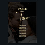 Numéro De Table Mariage de couverture photo Black Gold moderne<br><div class="desc">Un design mariage moderne en noir et or. Ce design contemporain est idéal pour les mariages du printemps, de l'été, de l'automne et de l'hiver en toute saison. Un élégant look noir 2 photo vellum superposé avec la typographie de calligraphie dorée. Un élégant design élégant de numéro de table de...</div>